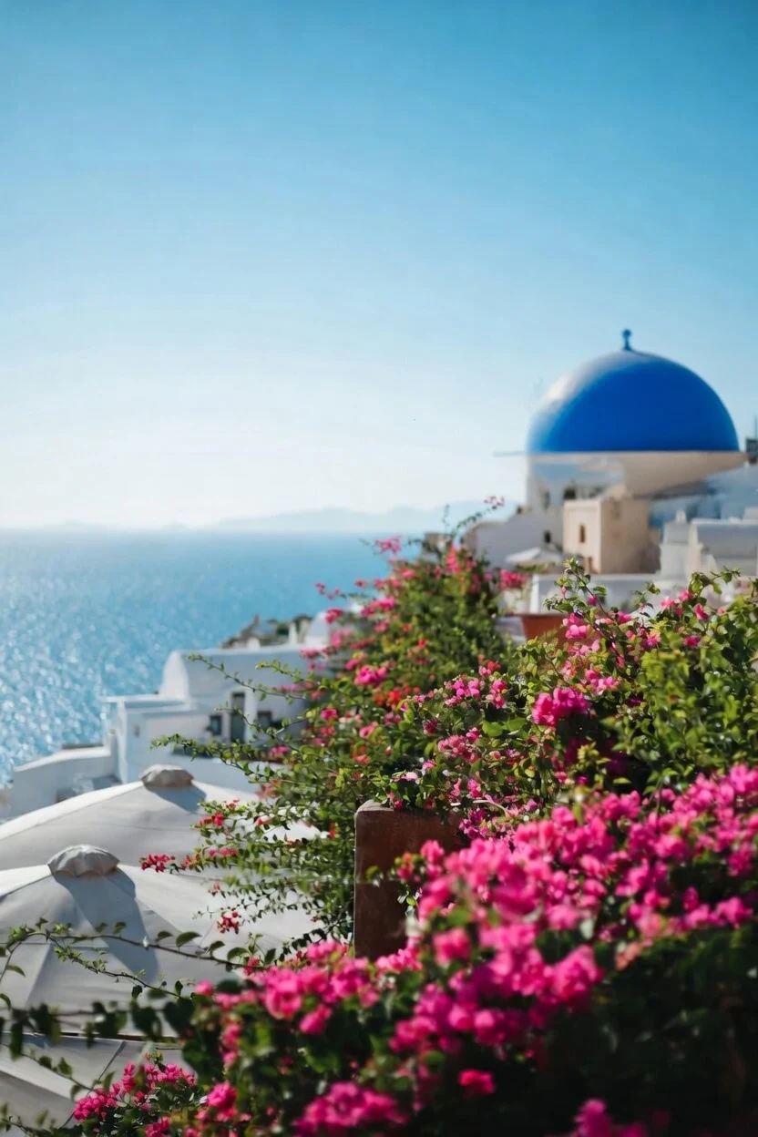 Santorini - The iconic whitewashed buildings of Oia with a blue-domed church overlooking the deep blue Aegean sea.